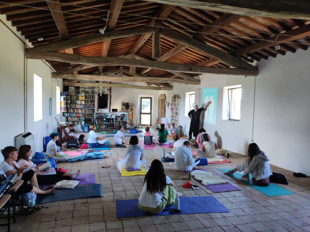 Hari Simran S.K. il fondatore del metodo e della scuola di riflessologia plantare Sat Guru Charan insegna in un'aula ai suoi studenti